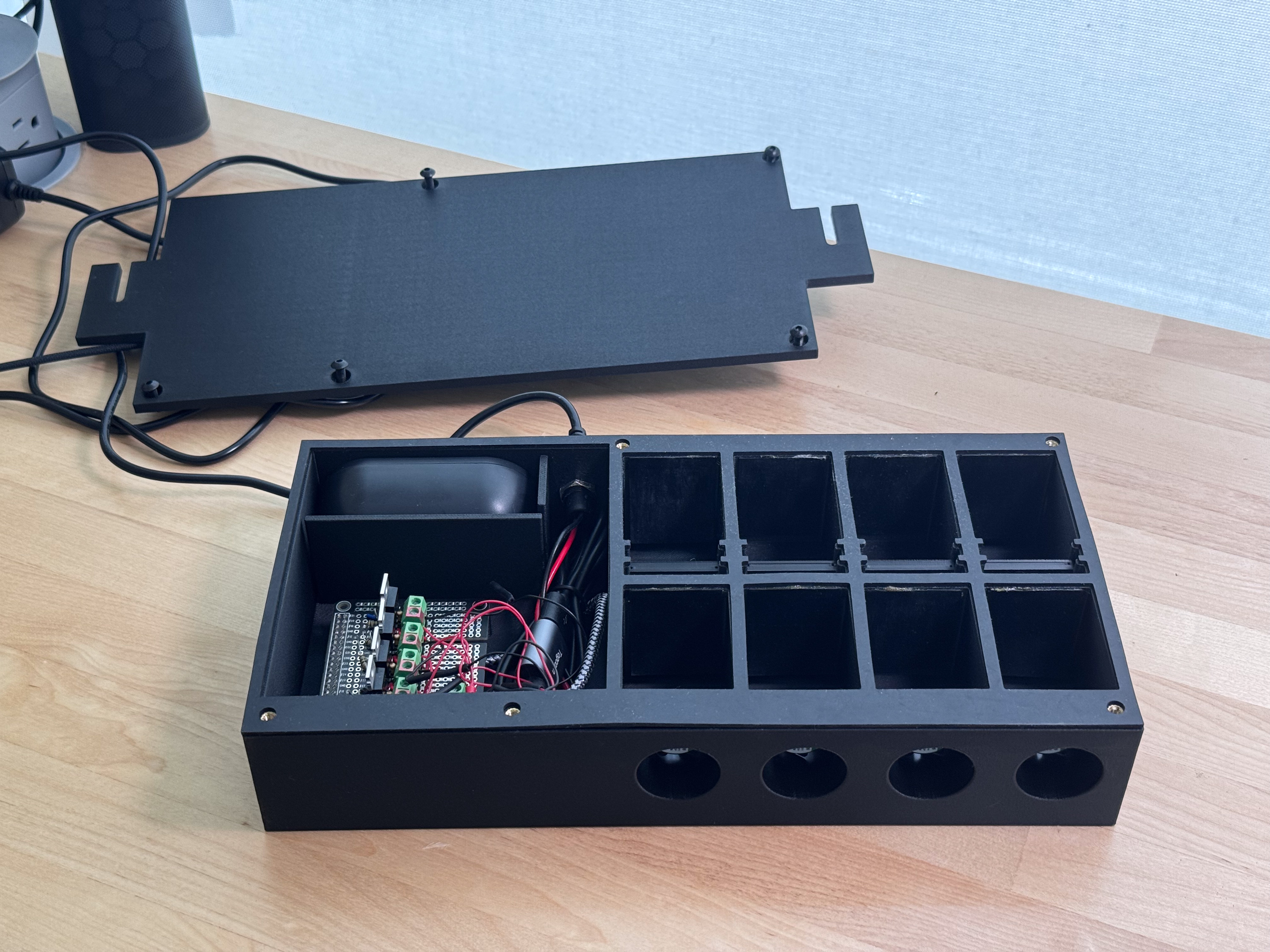 Photo of the device assembled and neater looking, with the lid off and next to the device Assembled