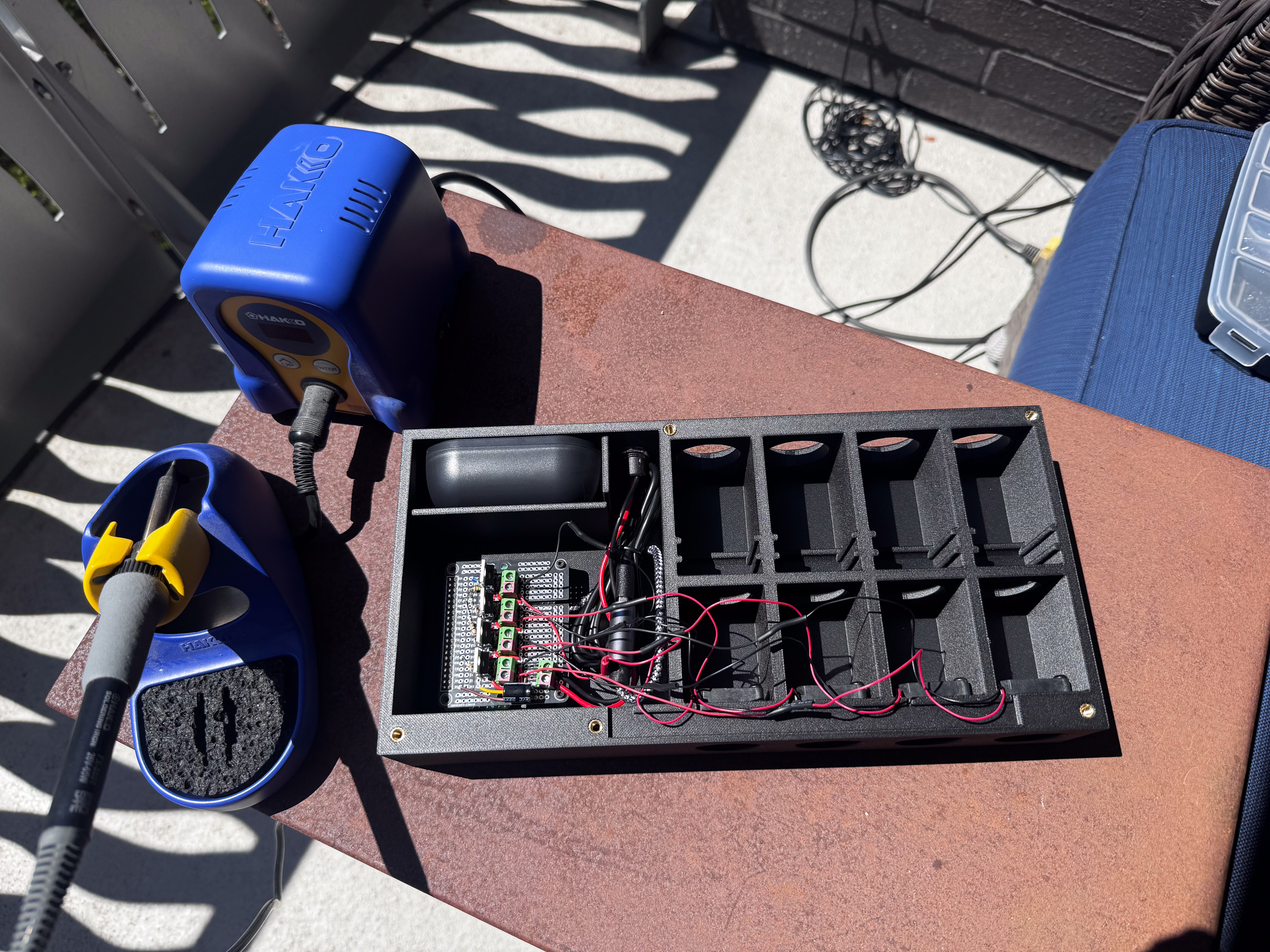 Photo of the device with its wiring and circuit boards visible, next to a soldering iron Wiring everything up