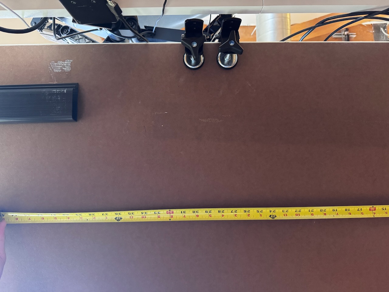Photo of holding a tape measure under the desk Measuring how much space I had to work with
