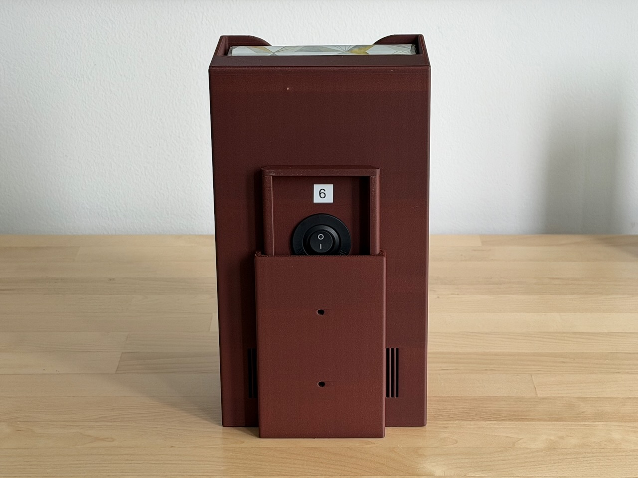 Photo of the assembled BleatBox from the back with the wall mount partially covering the switch and USB port. Assembled BleatBox, back view with wall mount slid halfway on