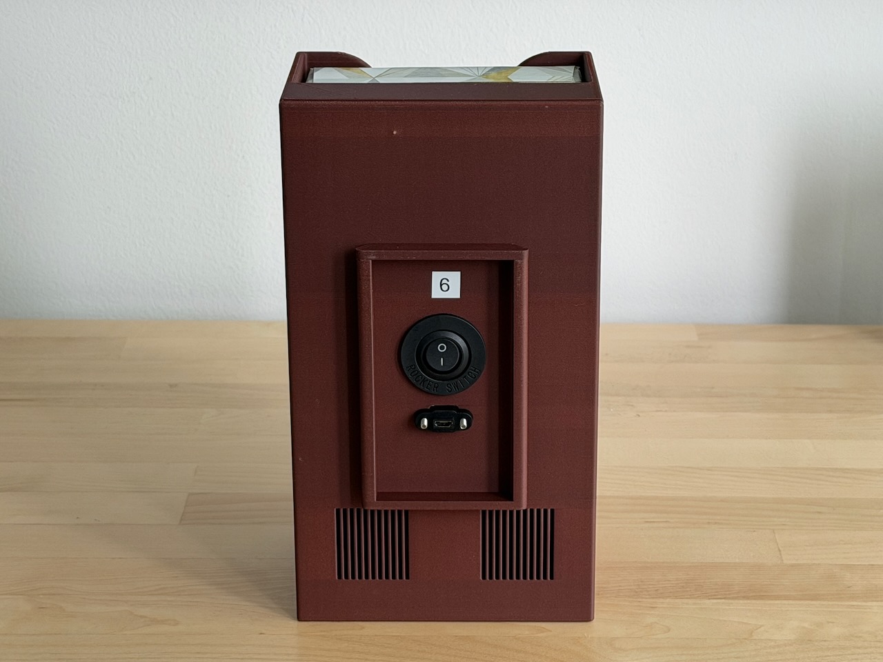 Photo of the assembled BleatBox from the back with speaker grilles, switch, and USB port visible Assembled BleatBox, back view
