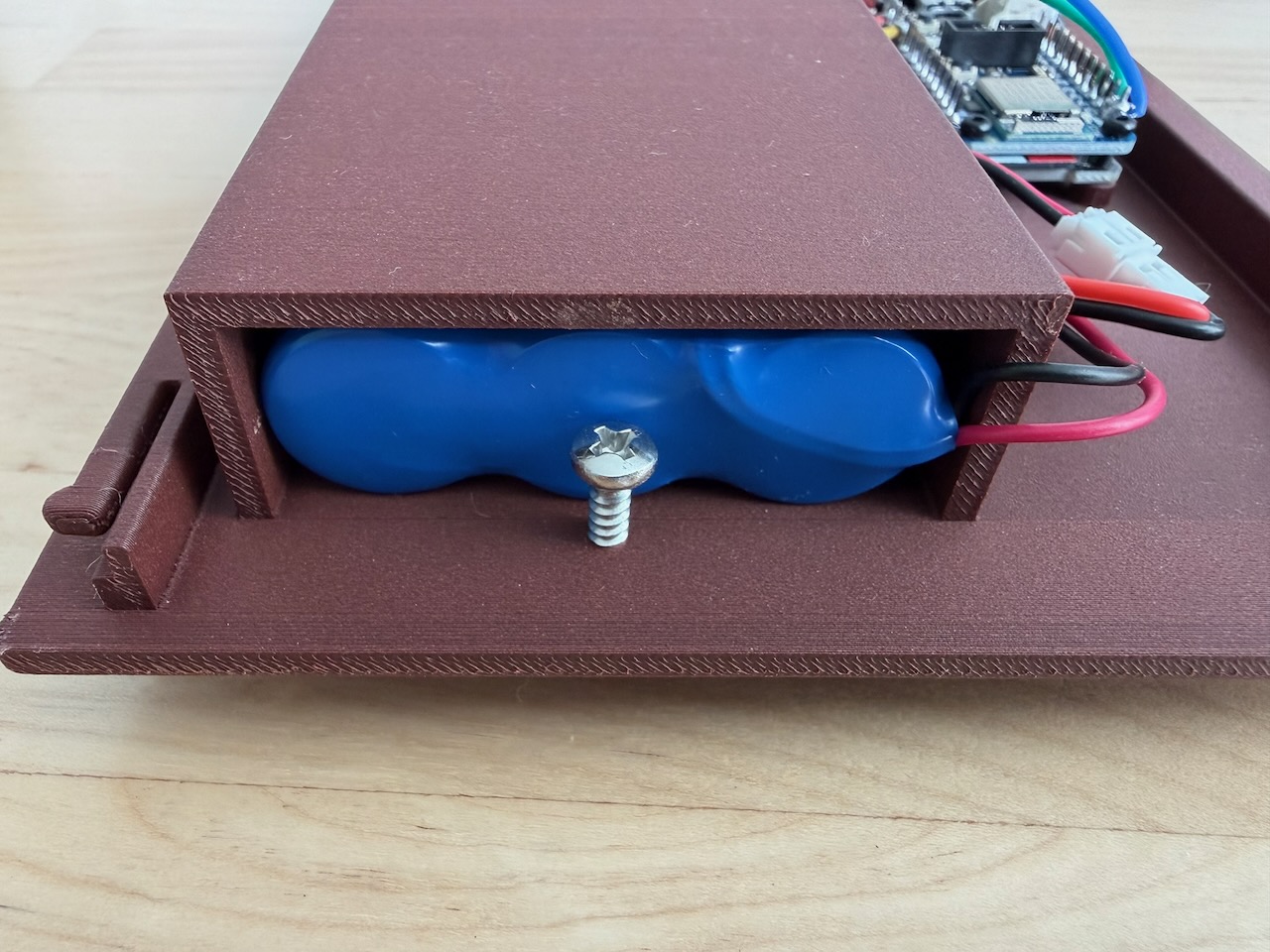 Photo of the battery, held in place by a screw. Battery retention jank